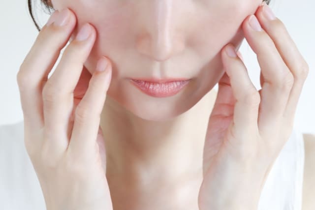 顔を両手で触れる女性