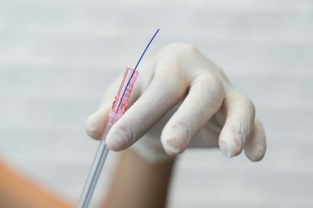 白い手袋をはめた手が糸リフトを持つ様子