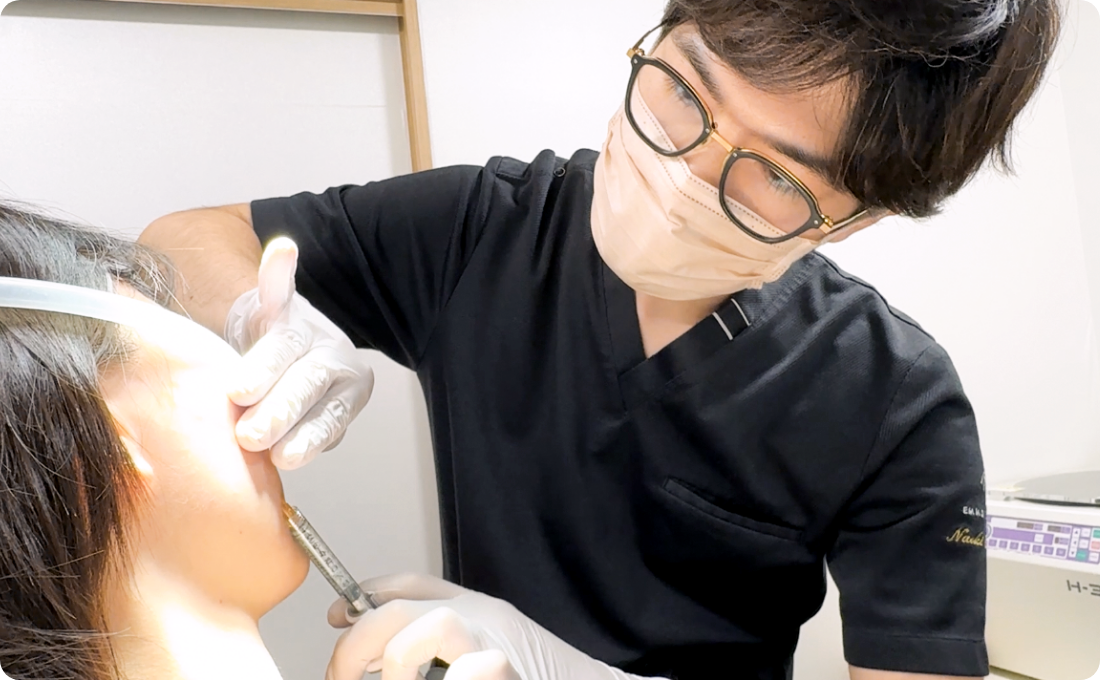 患者の顔に注射をする男性医師