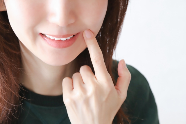 口元を触る女性