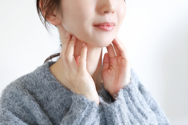 顎下を触る女性