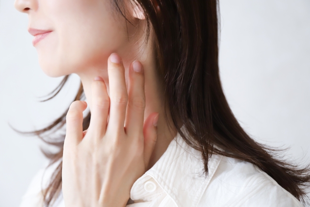 首元を触る女性