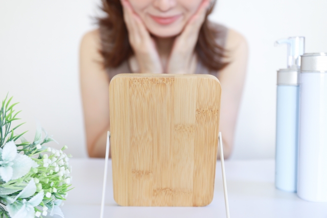 鏡を見る女性と化粧品