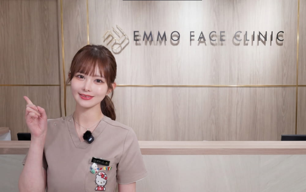 クリニック受付で指差しポーズの女性