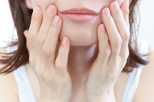 女性が顔に手を当てている様子