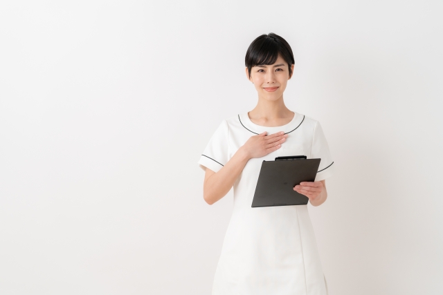 白衣を着てバインダーを持つ女性