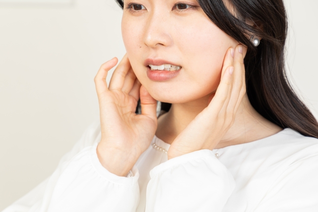 女性が顎のあたりに手を添えている様子