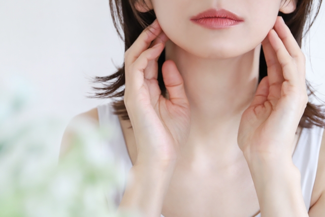 フェイスラインに手を添える女性
