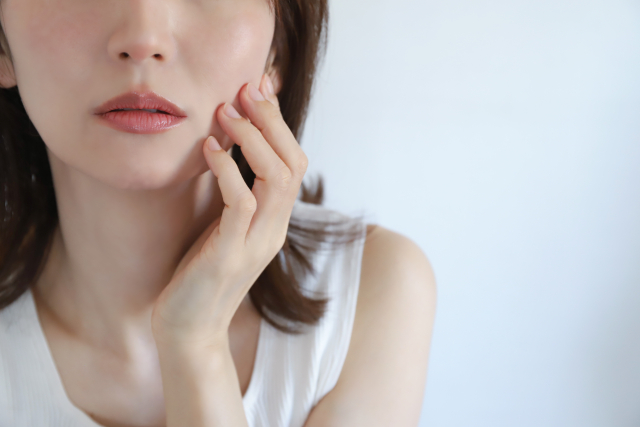 頬を触る女性